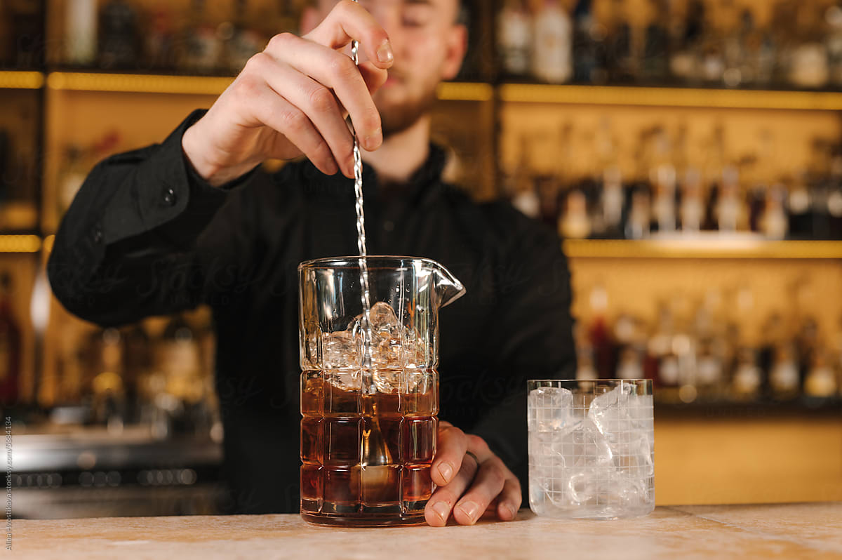 Barman blending cocktail in glass