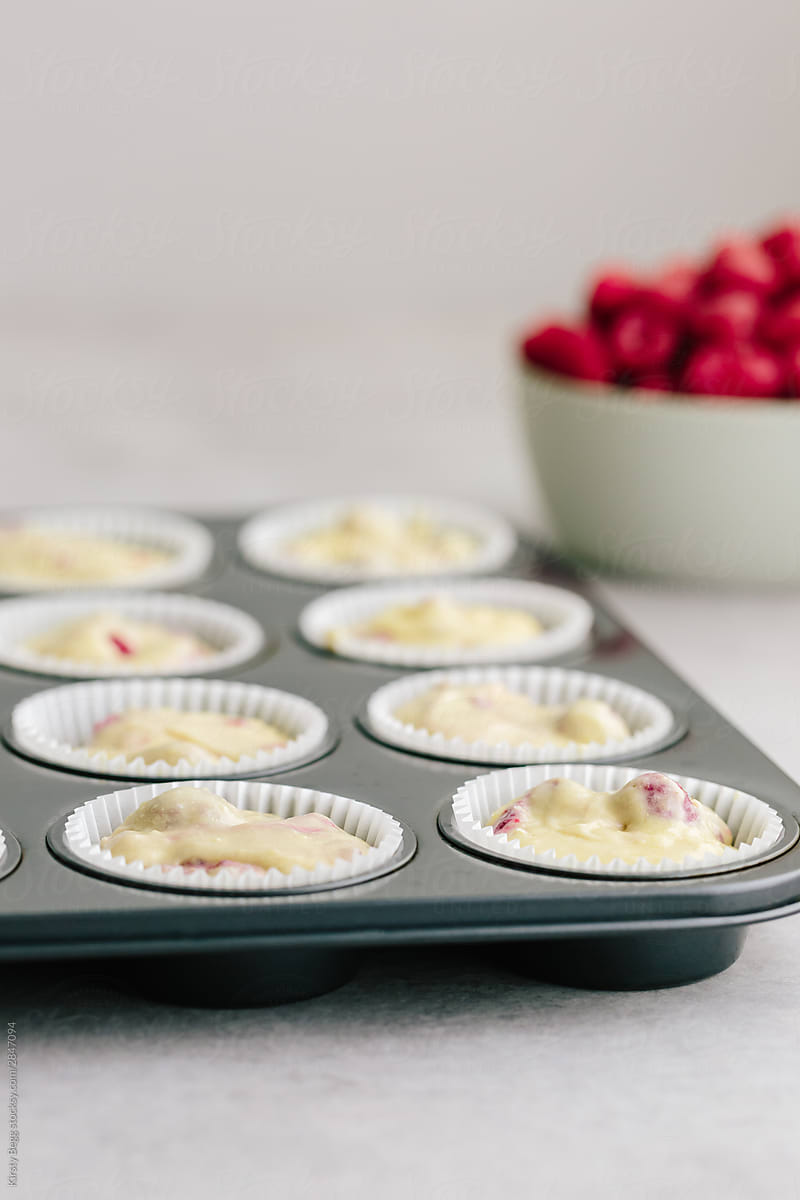 Unbaked raspberry muffin batter in baking tin