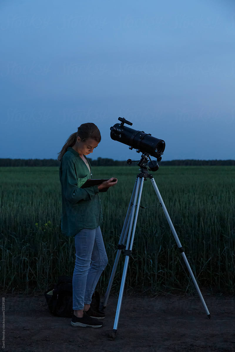 Young female with telescope using tablet near field