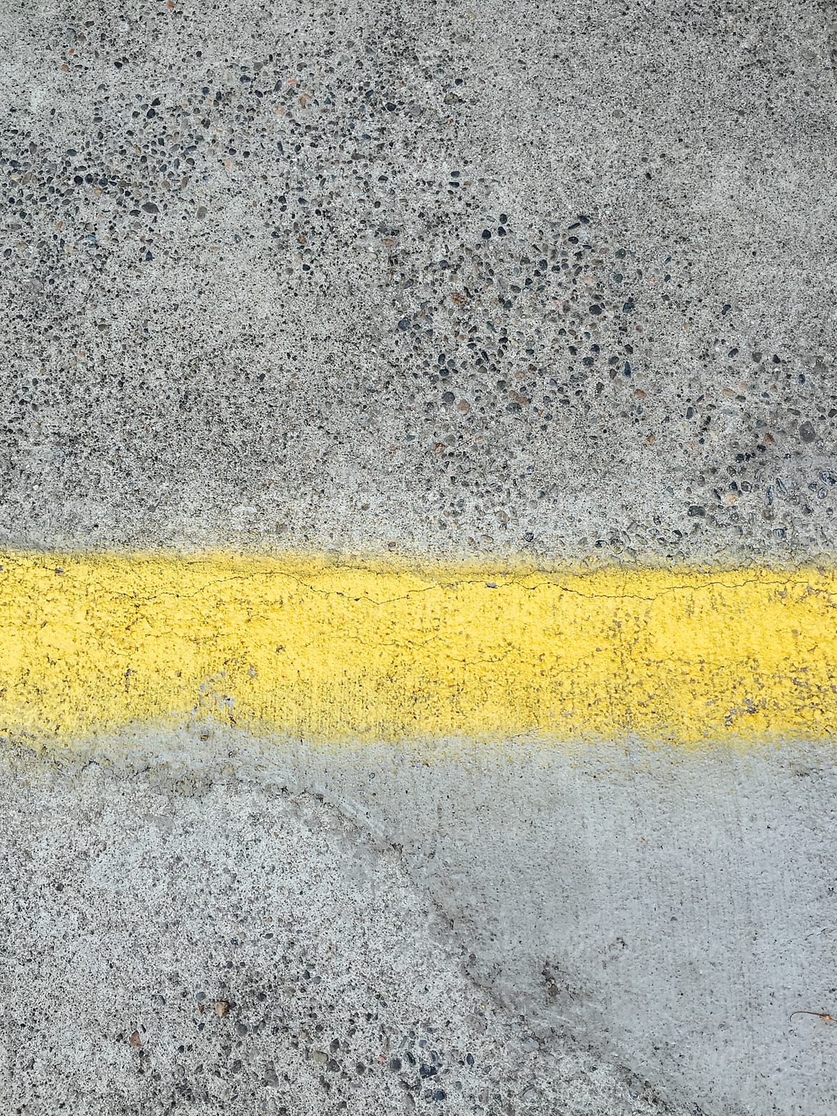 Painted yellow stripe on urban sidewalk and street