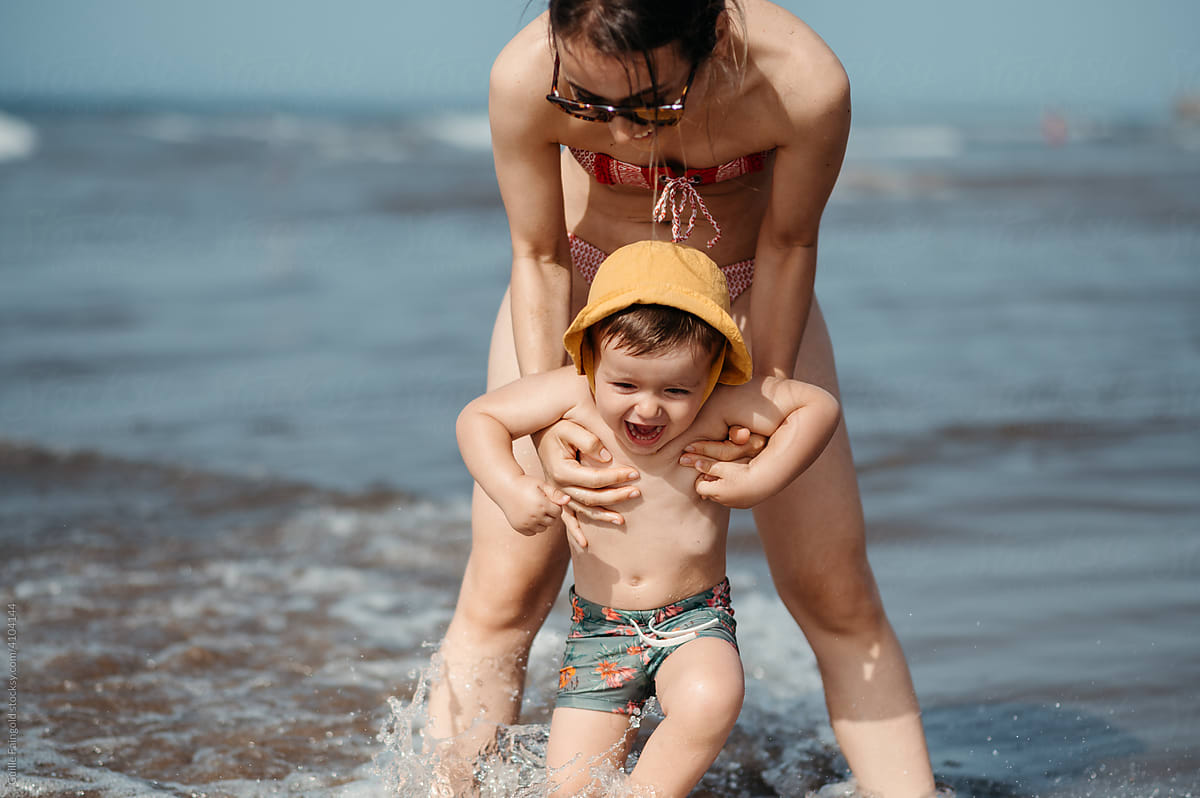 Woman with boy in waves