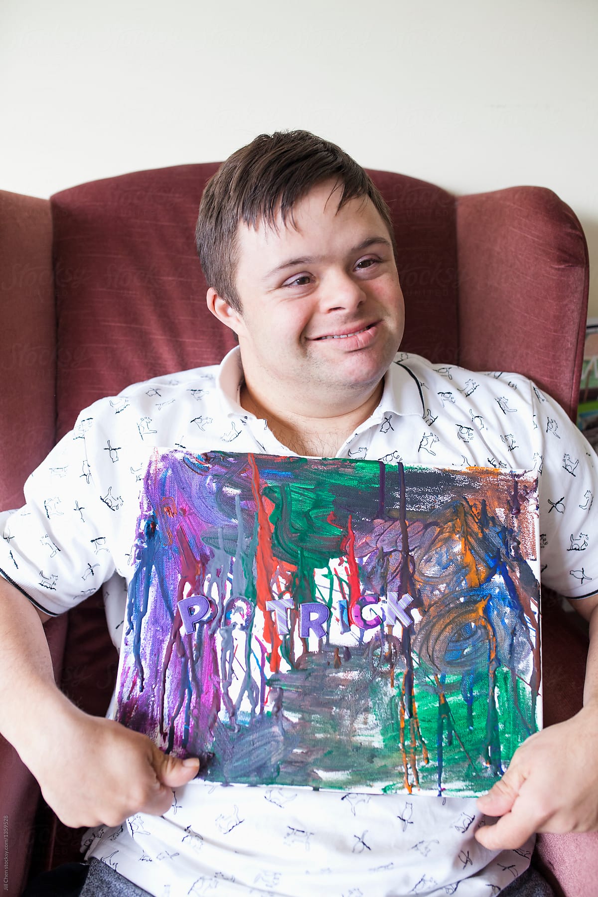 Man with special needs proudly shows off his painting.