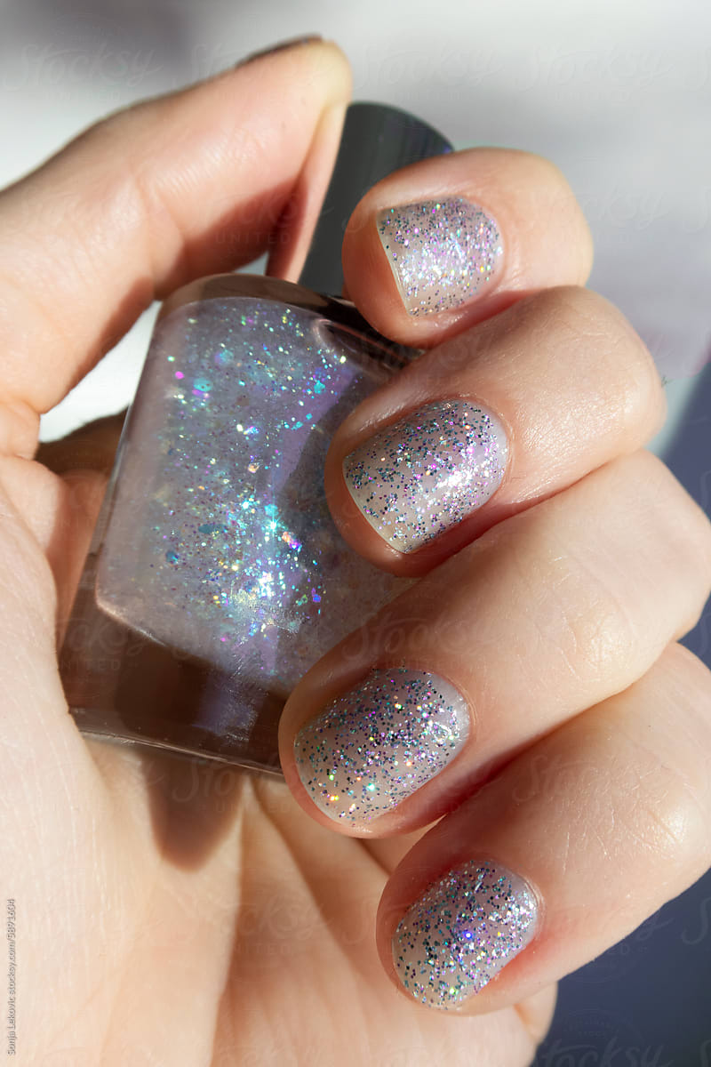 Transparent blue sparkling shiny nails closeup