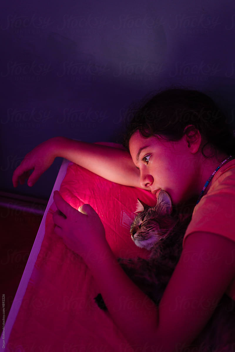 Teenager watching video on mobile phone at night