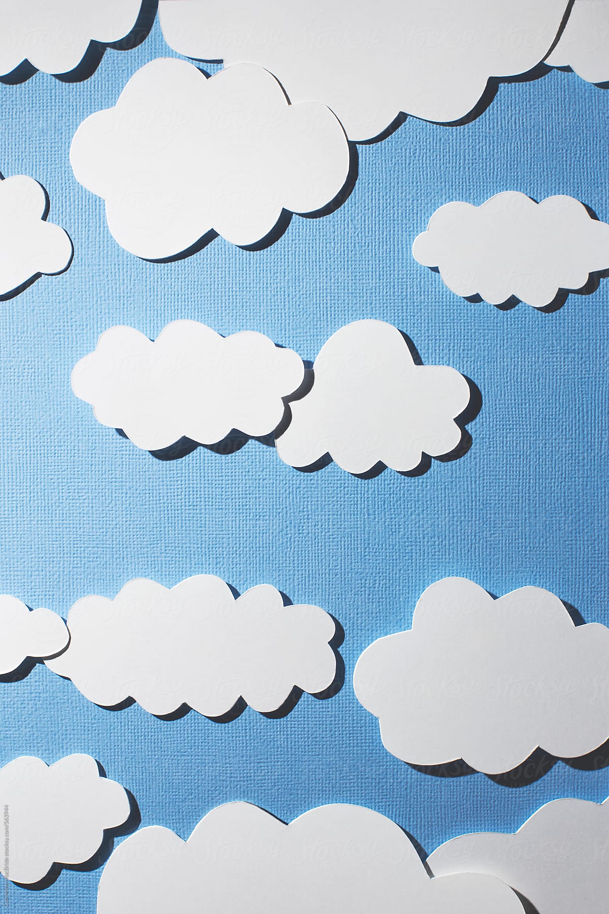 white paper clouds in blue paper sky...