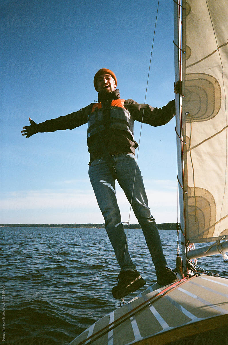 Man sailing on sailboat at lake