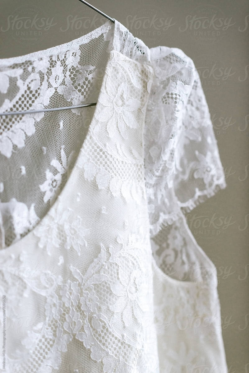 close up of a lace wedding dress on a clothes hanger