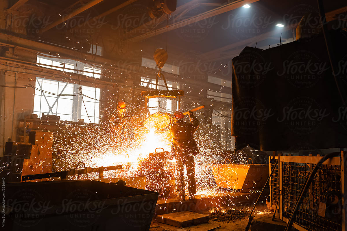Unrecognizable workers in sparks of liquid metal