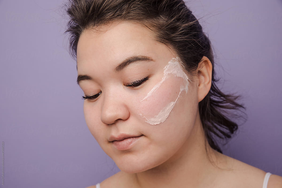 Young east asian woman removing clay mask off her face