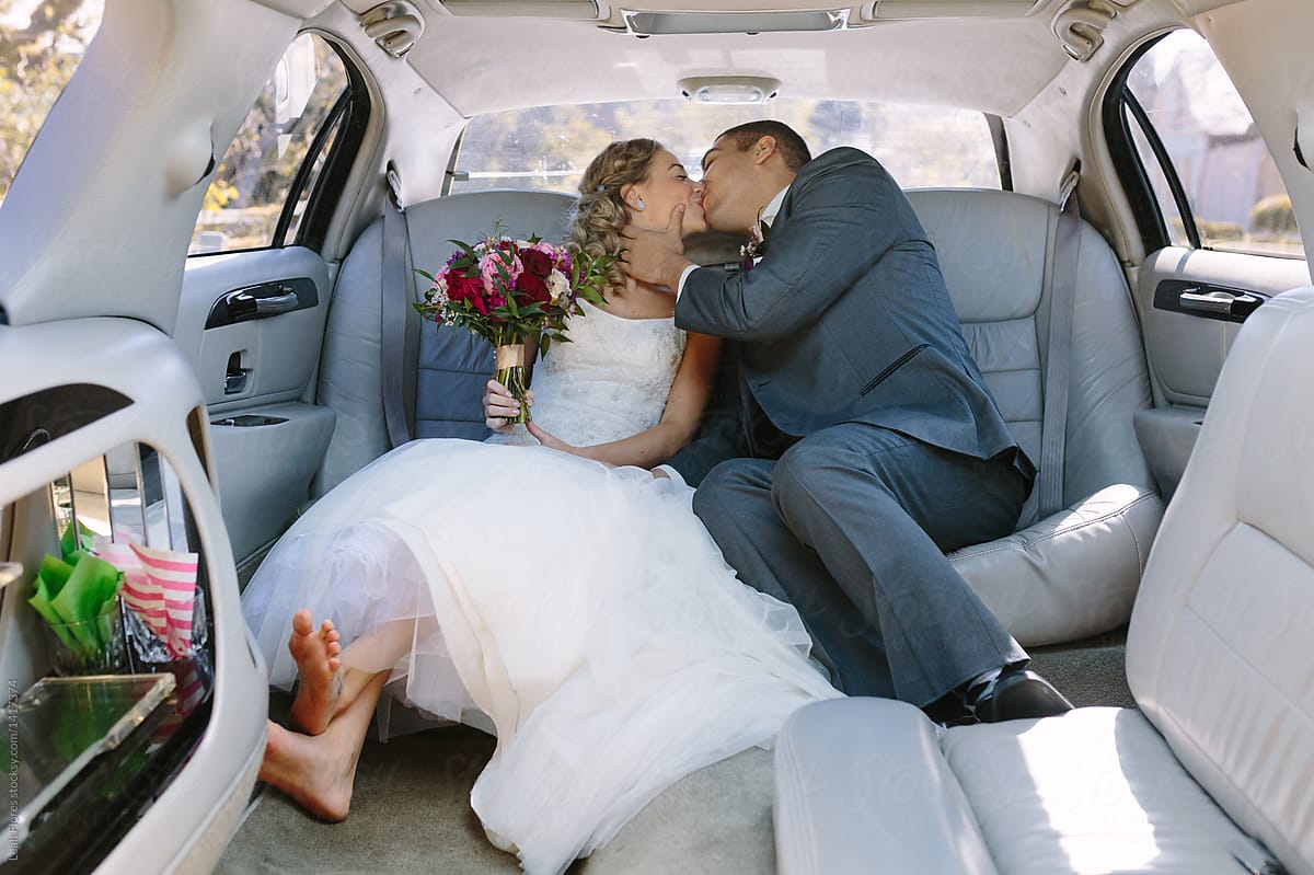 Cute Wedding Couple Kissing in the back of a Limousine