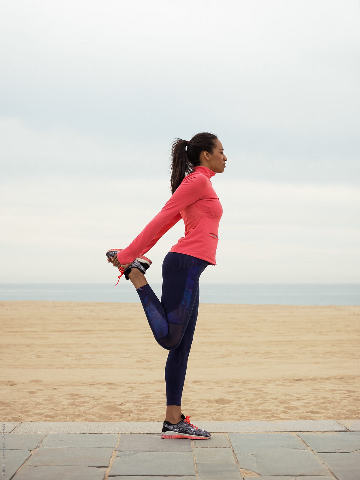Flexible Black Woman Stretching On Beach by Stocksy Contributor Milles  Studio - Stocksy