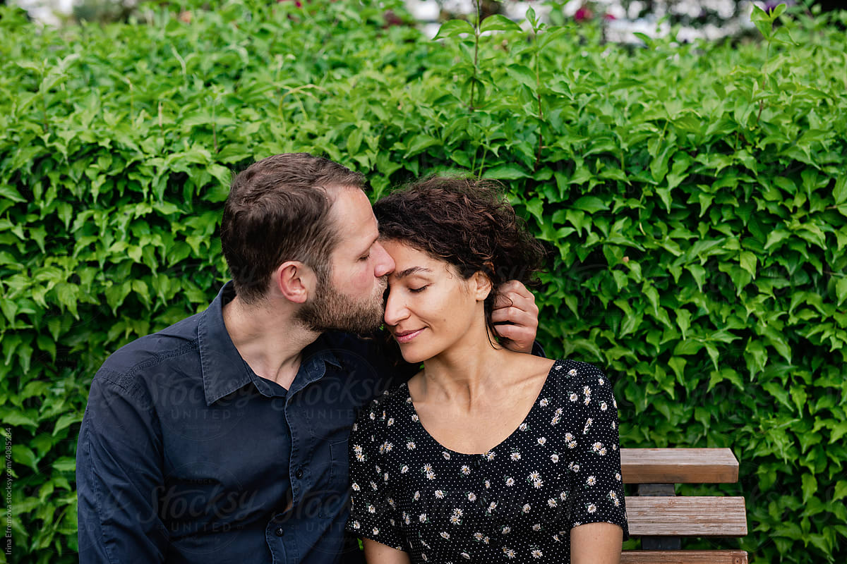 Guy kissing a girl on park bench