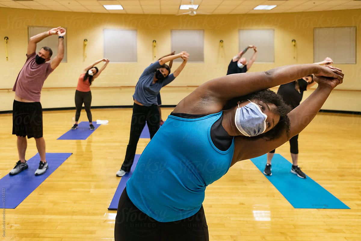 Gym: Instructor Wearing Mask Leads Class In Stretch