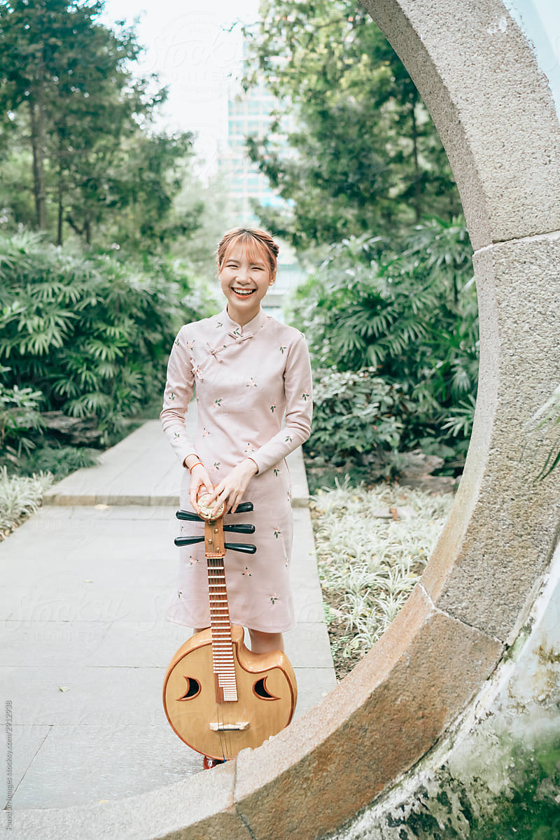 Asian young woman in cheongsam with a Chinese instruments zhongruan