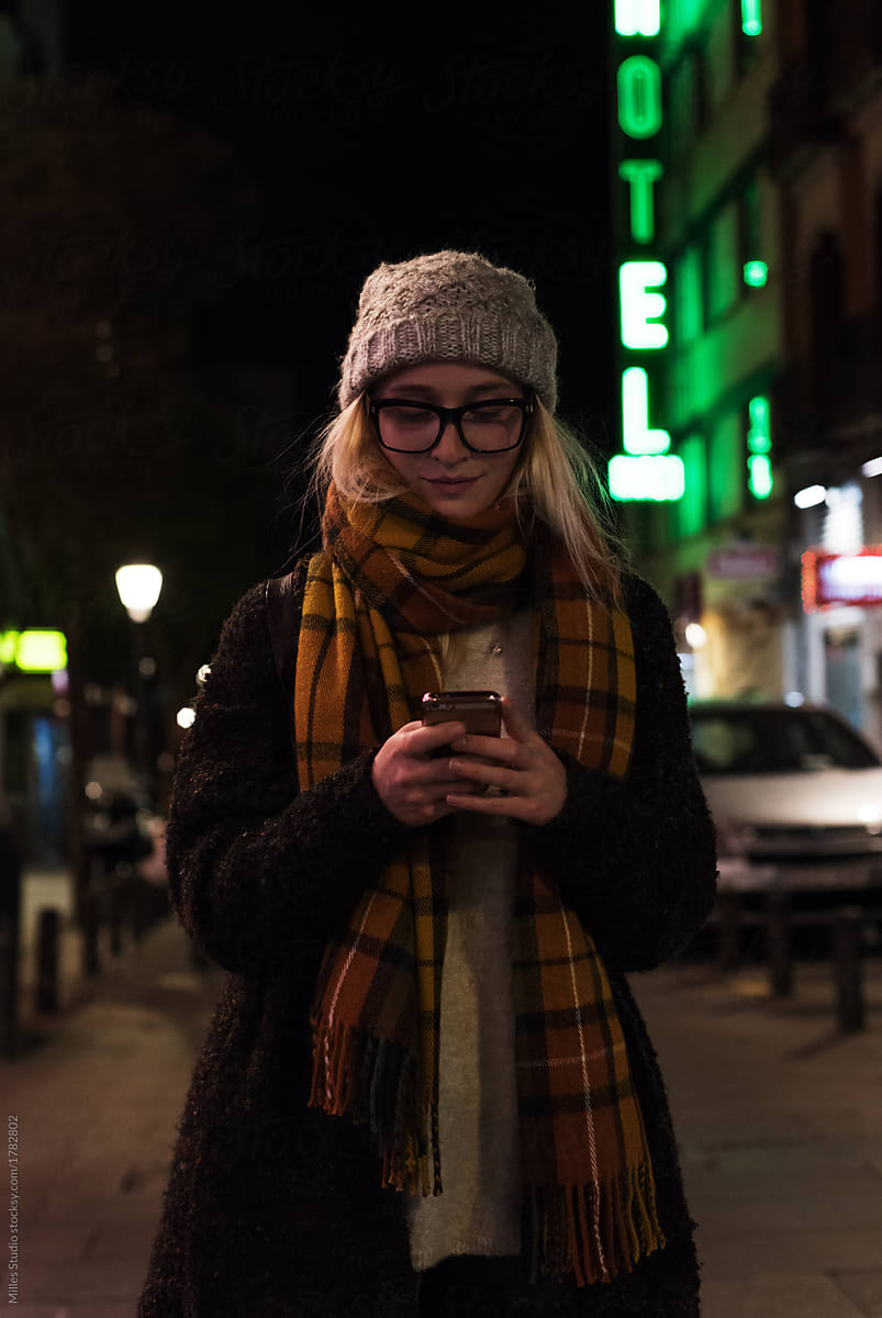Woman with phone in dark cold city