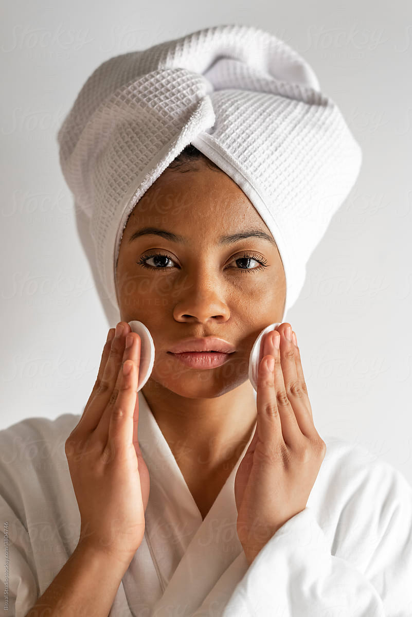 Black woman applying tonic on face