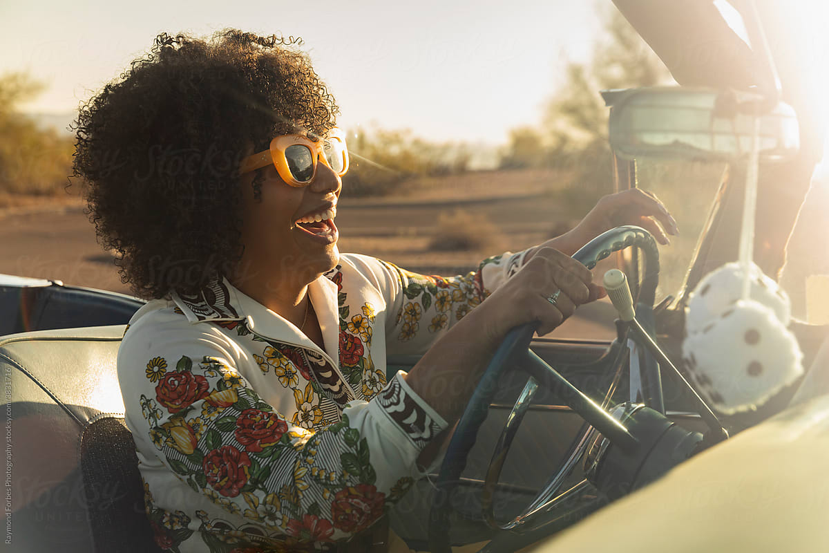 Happy Beautiful Black woman in Vintage Car behind the wheel