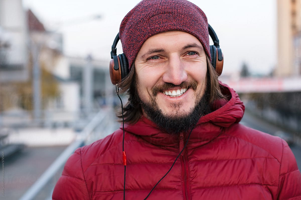 Street portrait of smiling man with earphones outdoor