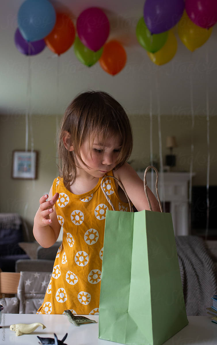 Child Having Birthday Party Reaches into a Gift Bag