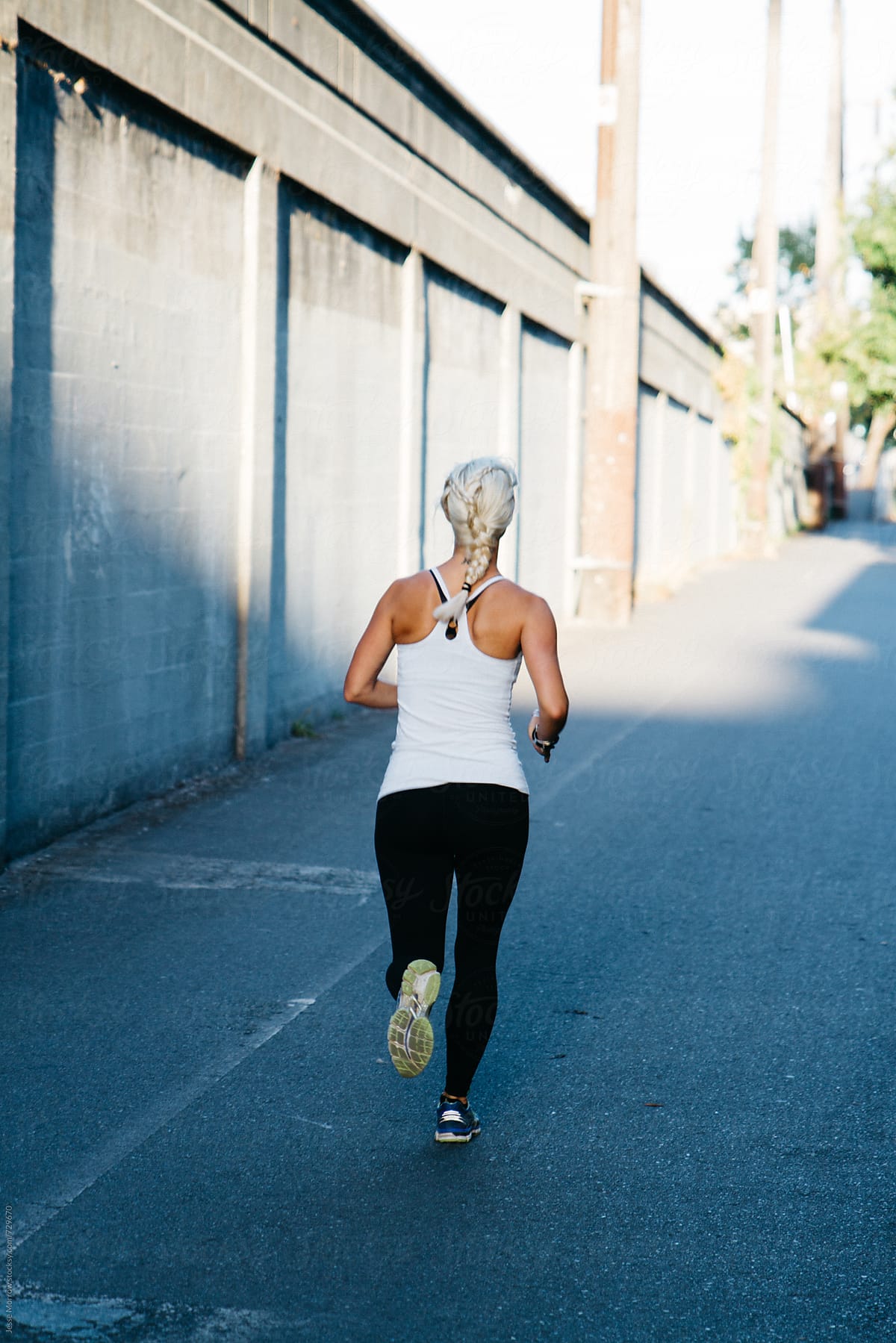 Young Woman Running In Fitness Clothing Through Urban City Environment by  Stocksy Contributor Jesse Morrow - Stocksy