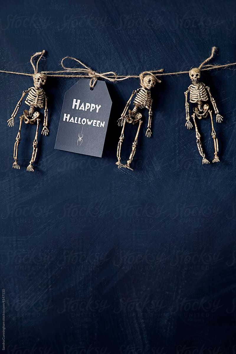 A note with tiny skeletons hanging with string