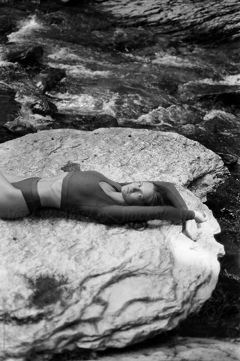 A woman relaxes on a rock
