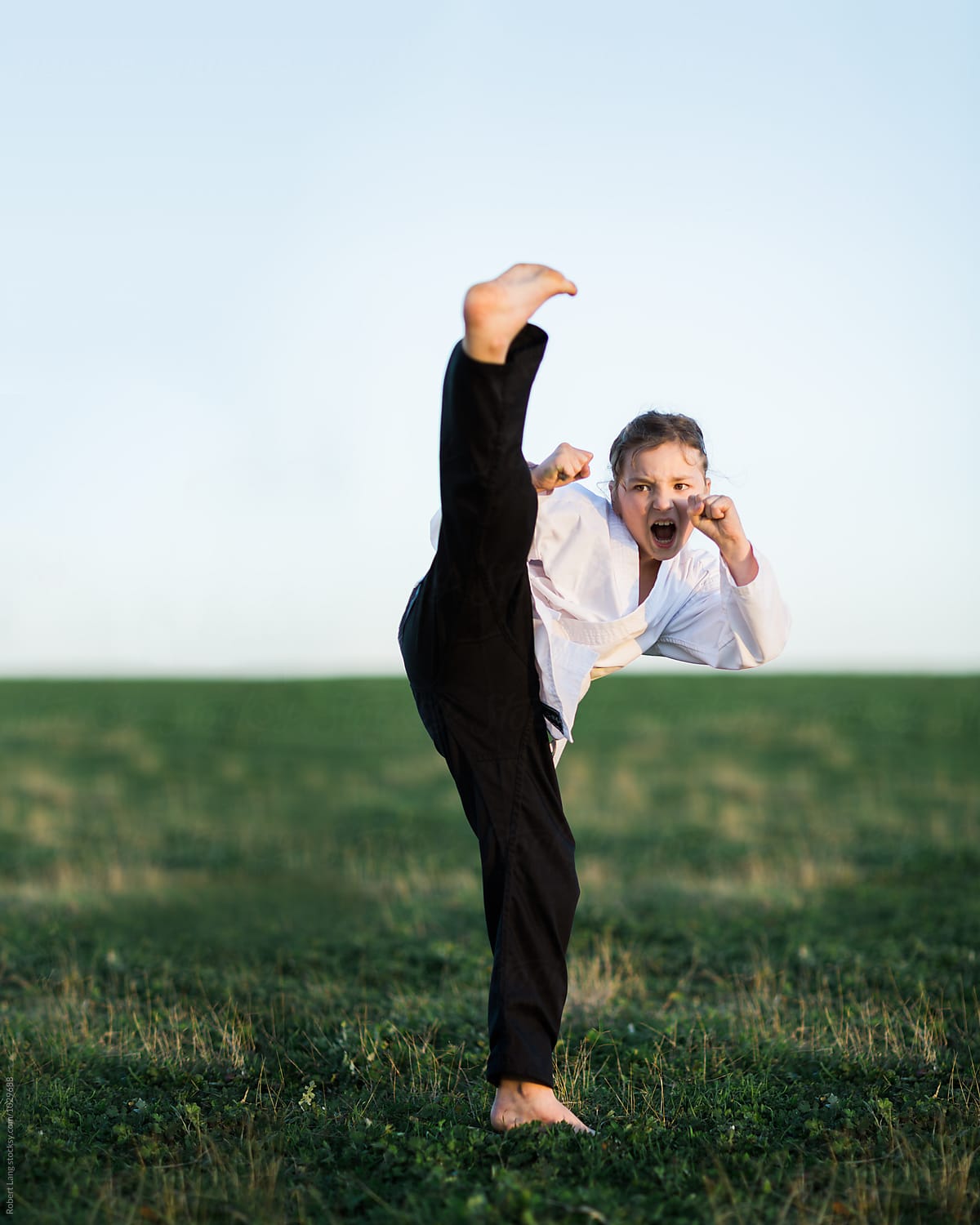 Girl doing martial arts outside on grass