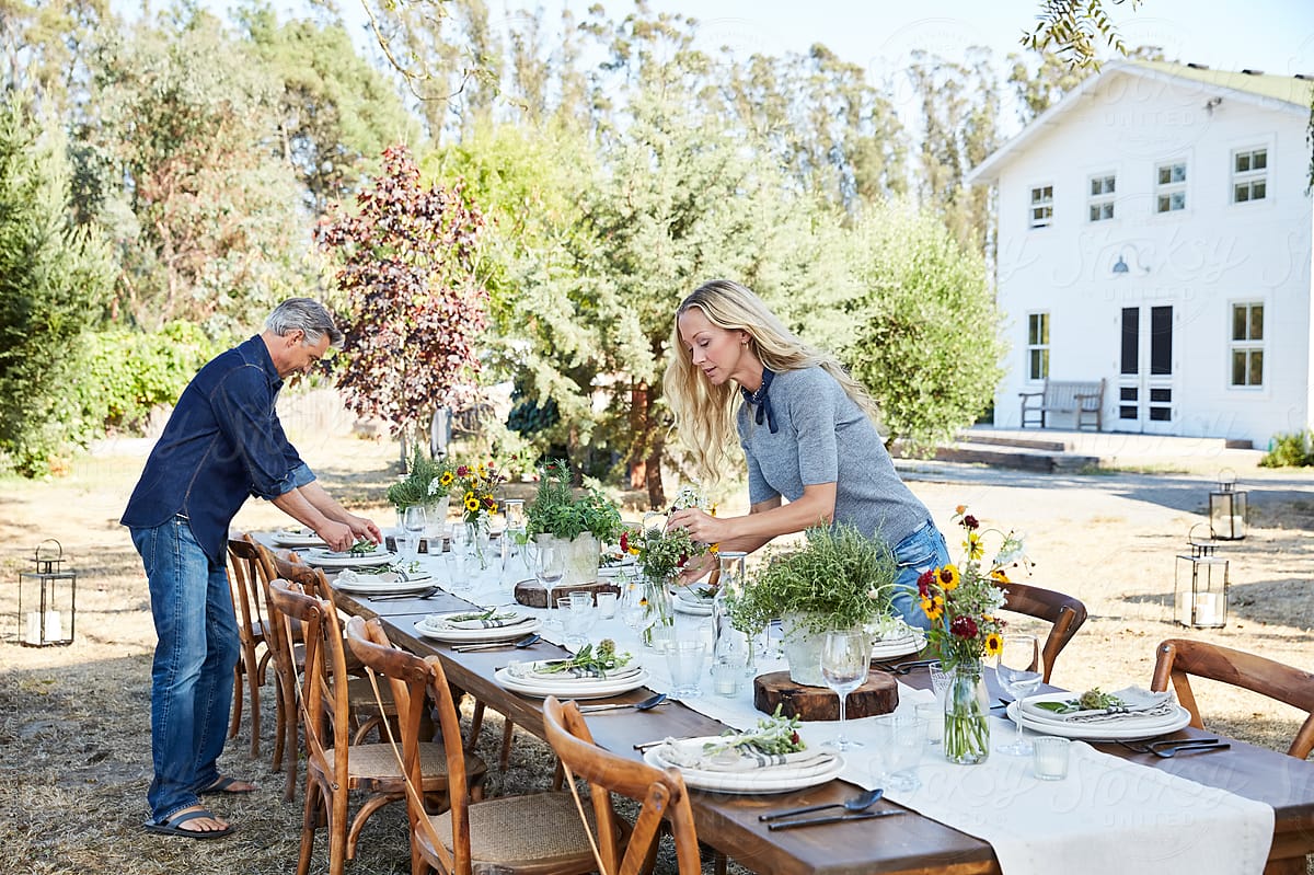 Mature couple setting the table for a farm to table dinner party