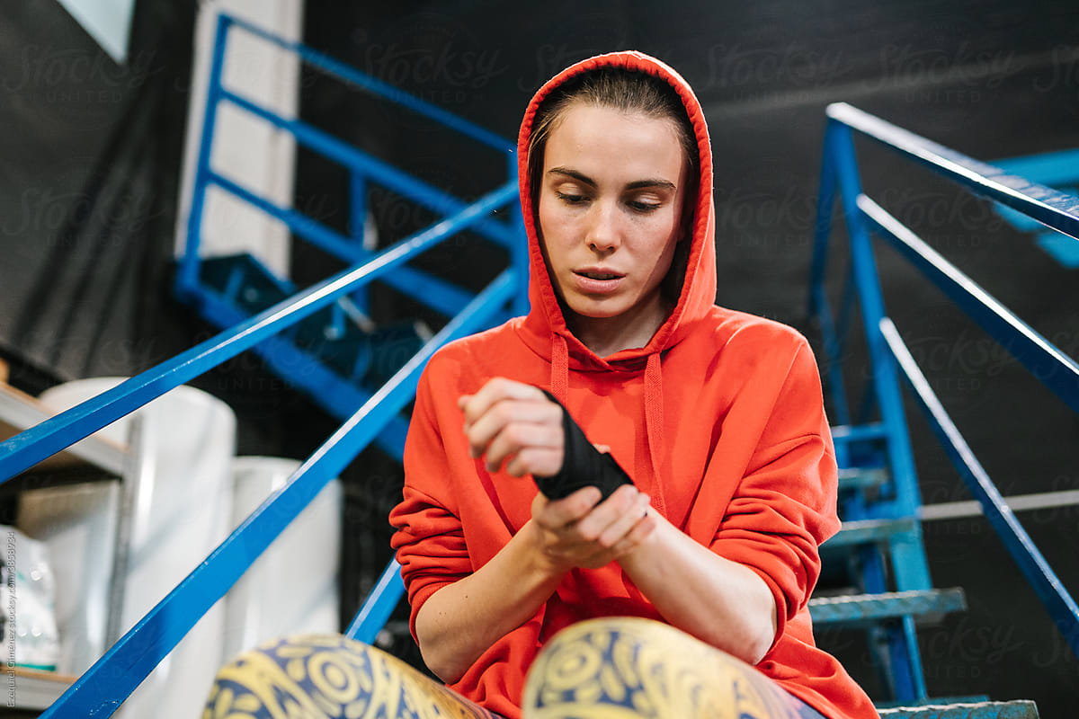 Female fighter looking at the elastic boxing bandage