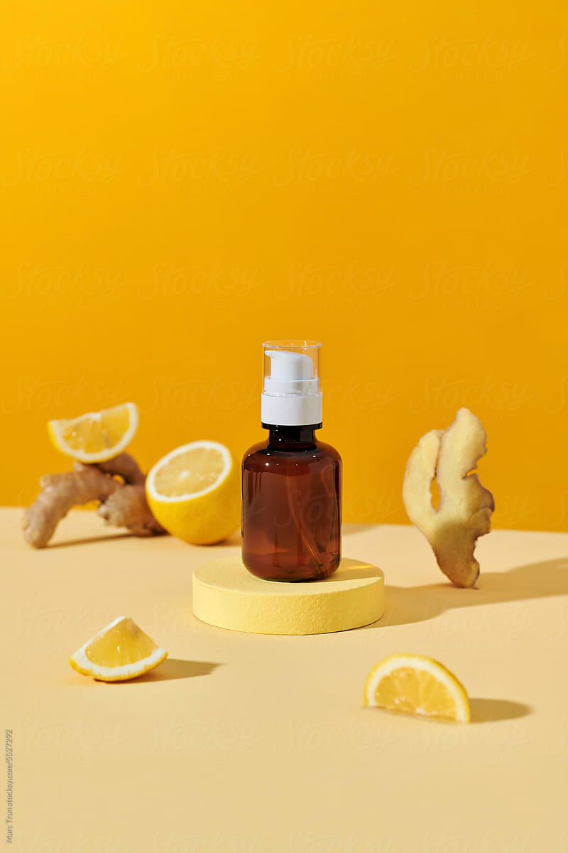 Sunlit scene of brown glass cosmetic serum bottles with lemon