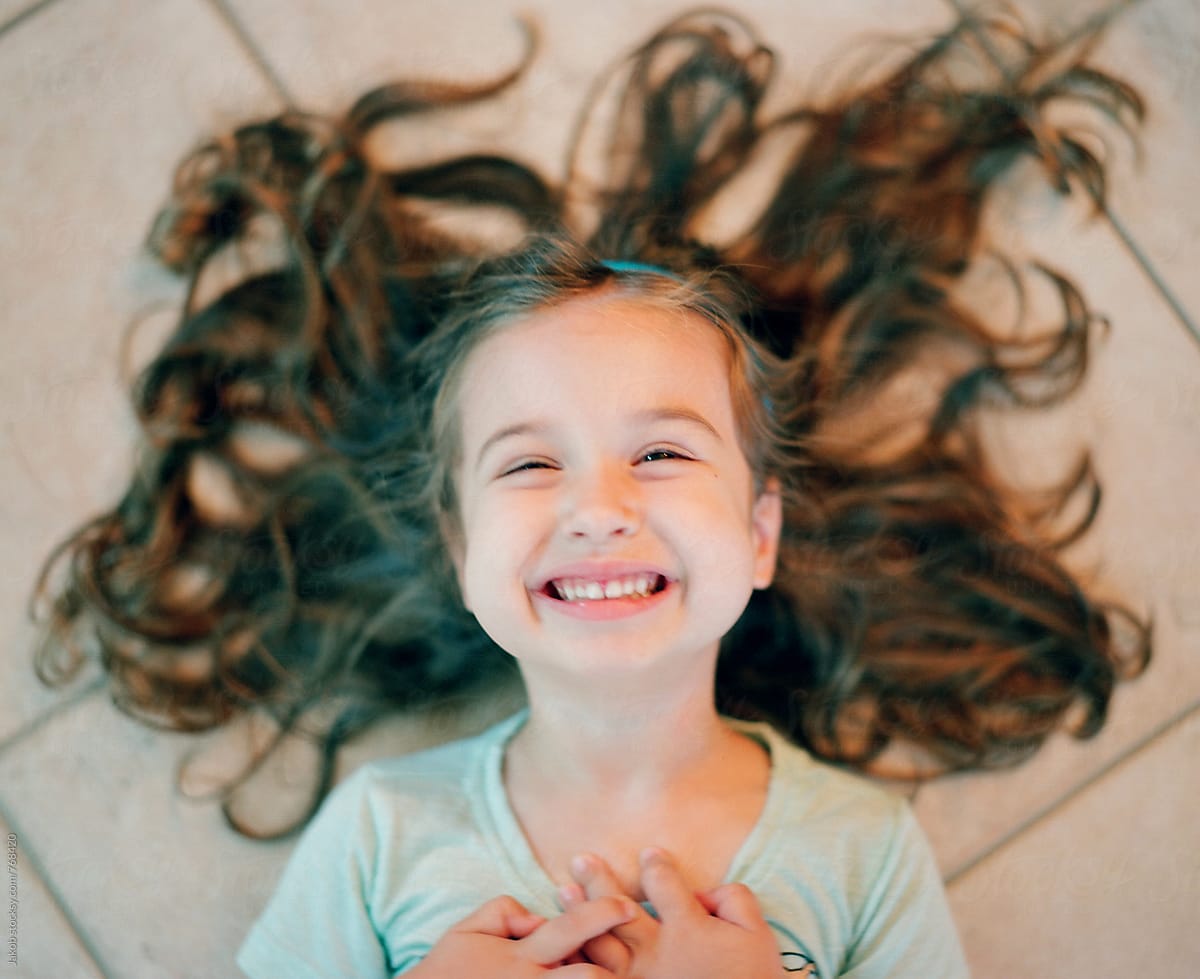 Young Girl Laughing While Laying Down With Her Hair Spread Out Soft 