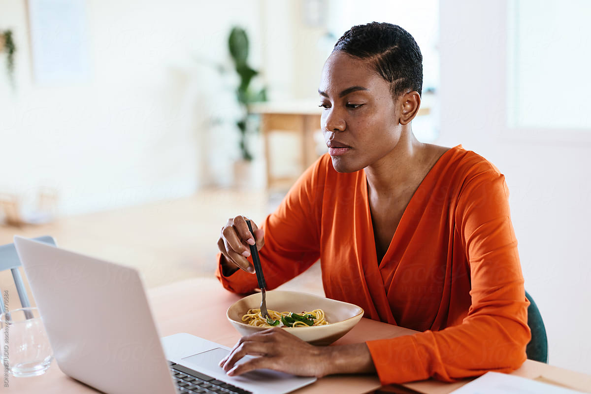 Black freelancer using netbook during lunch