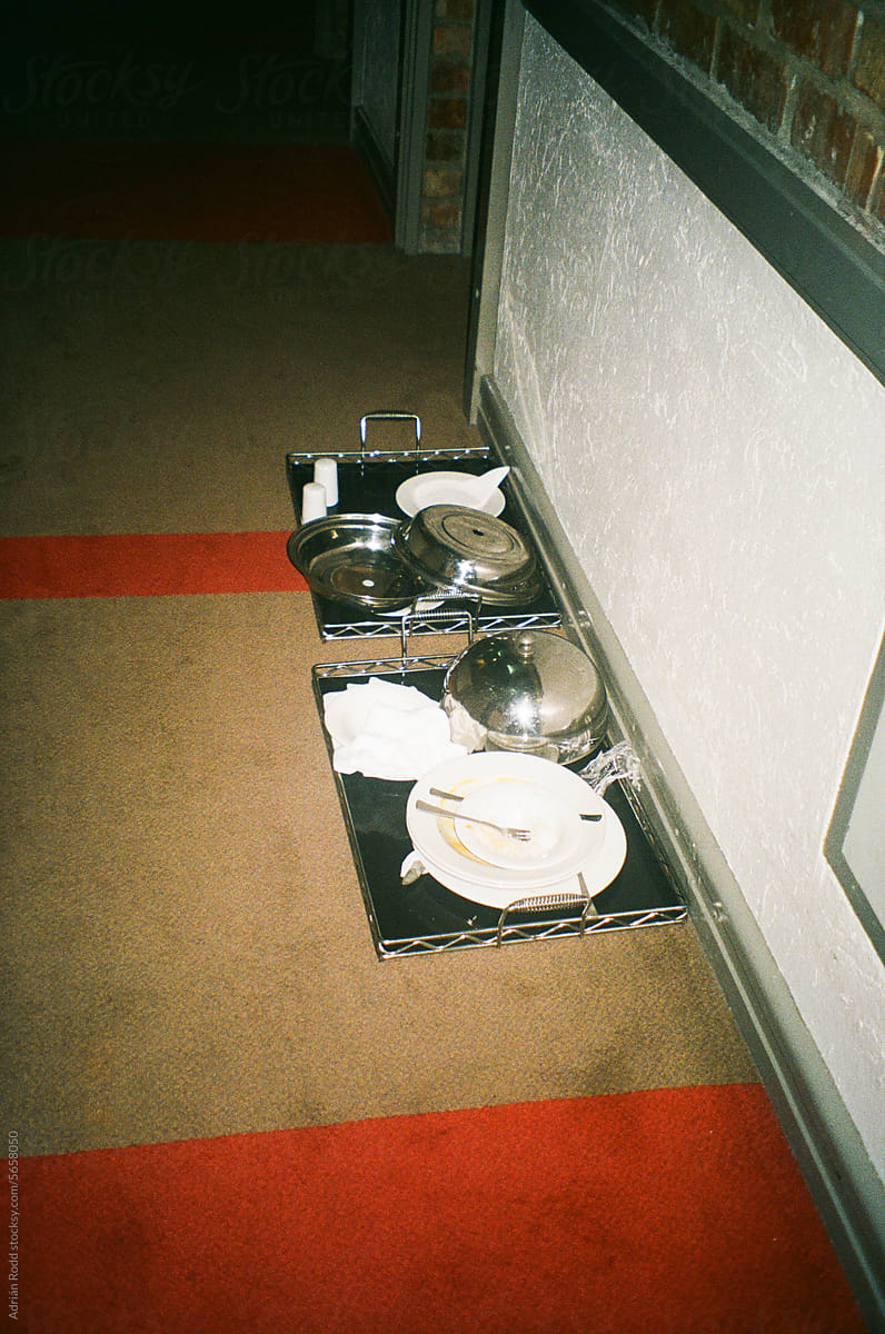 Discarded Plates of Food in a Hotel Corridor