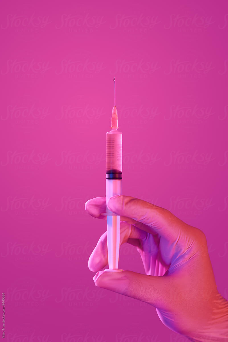Doctor hand in white glove hold syringe