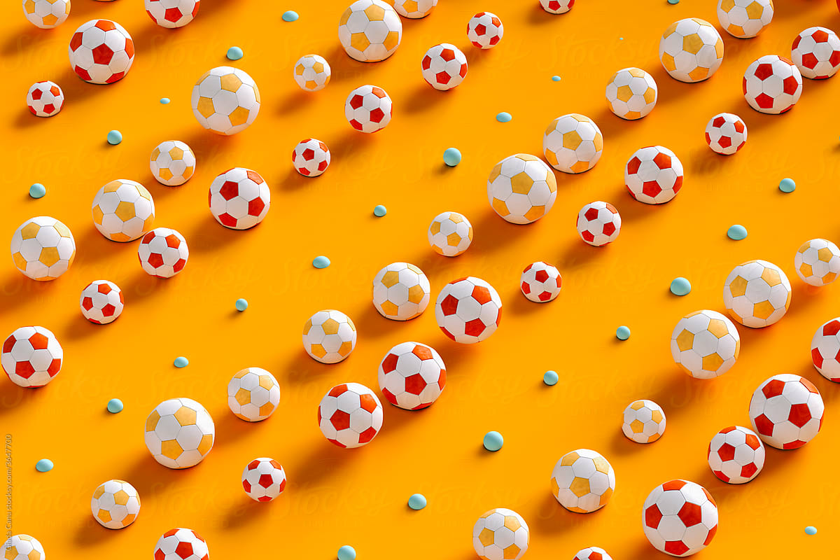 Soccer balls arranged on orange background