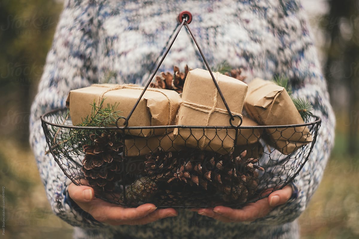 Woman with basket of rustic Christmas presents / gifts