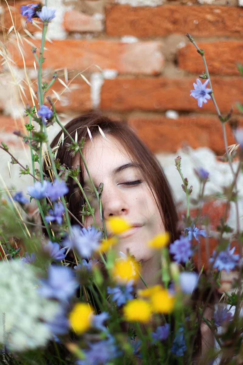 Hazy portrait of lovely woman laying her head on flowers