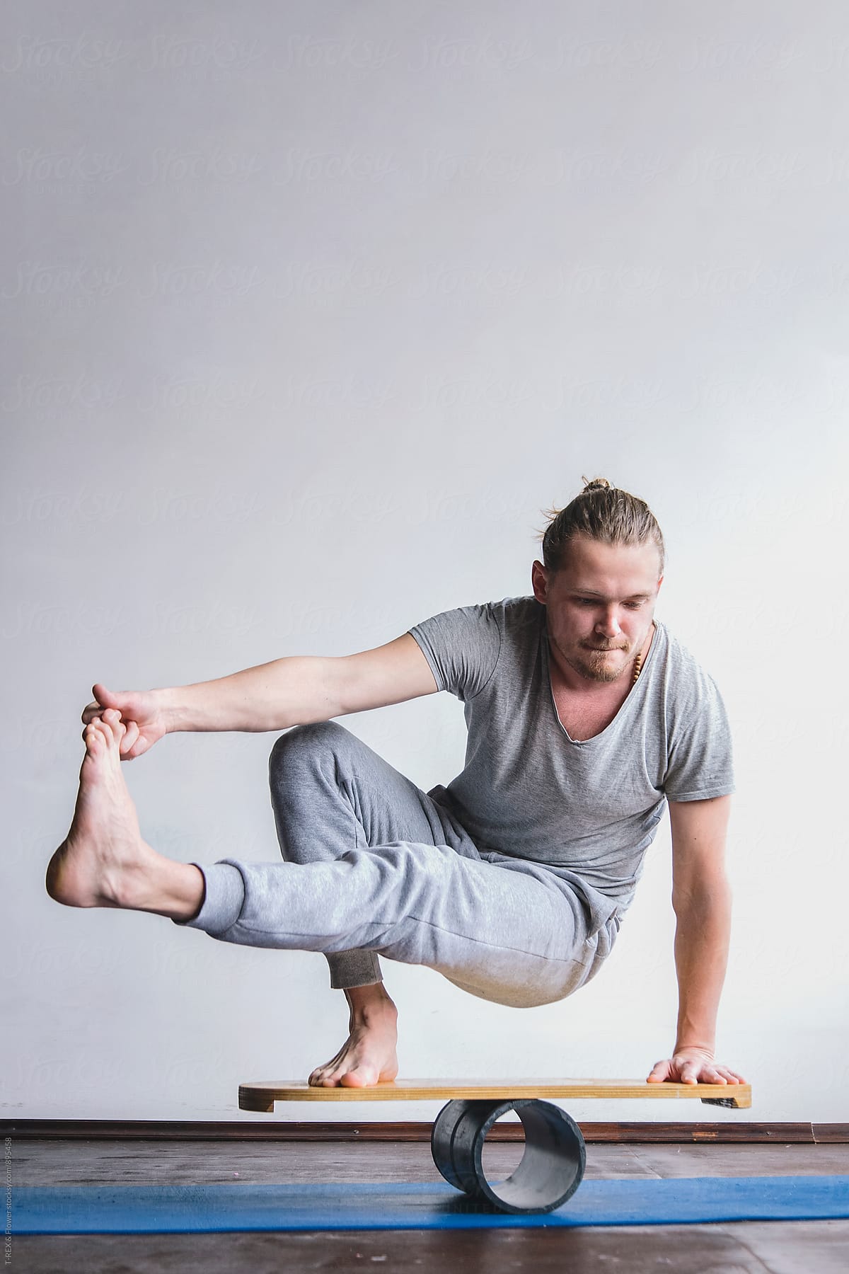 Man doing yoga exercise on balance board