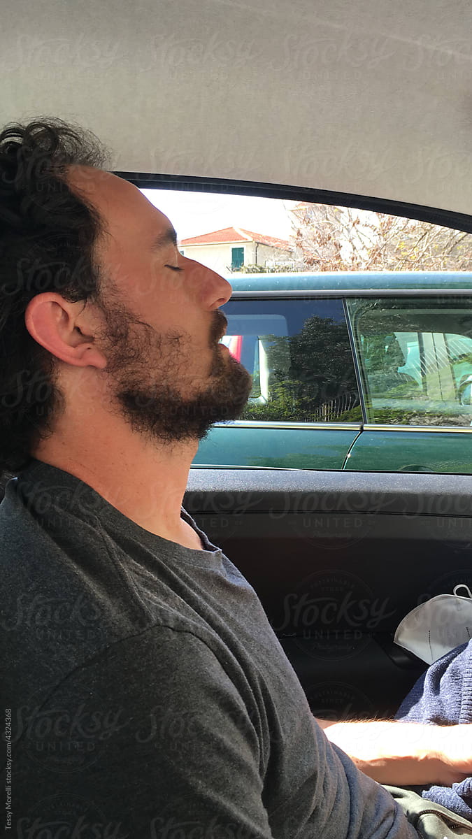 UGC man with a beard taking a nap in the car