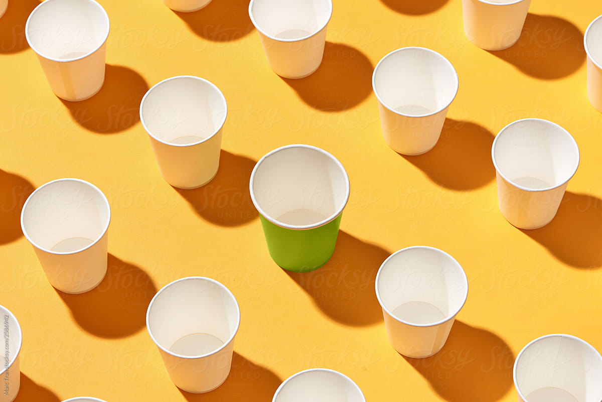 Large Group Of White Disposable Plastic Cups On Yellow by Stocksy