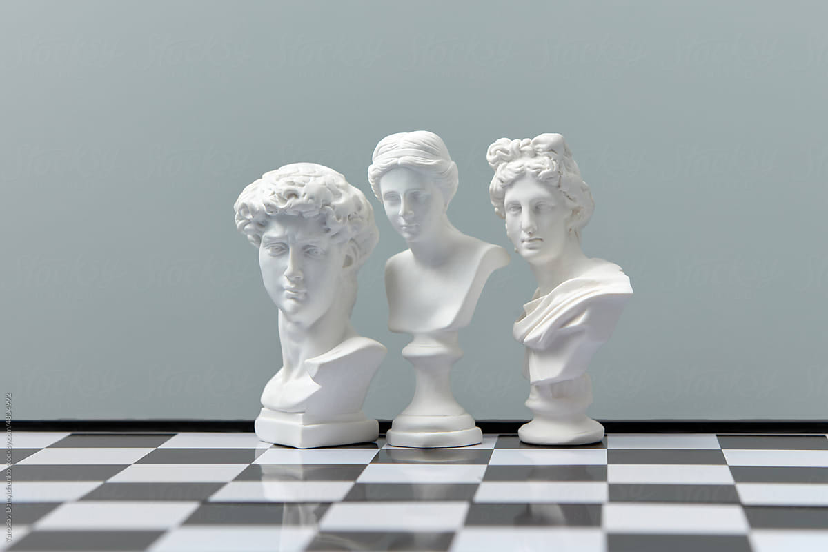 White gypsum statues on chessboard.