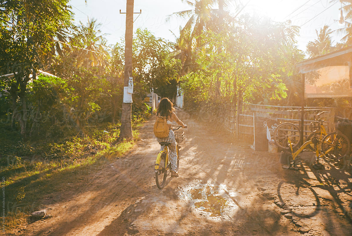 Woman riding bicycle on tropical island