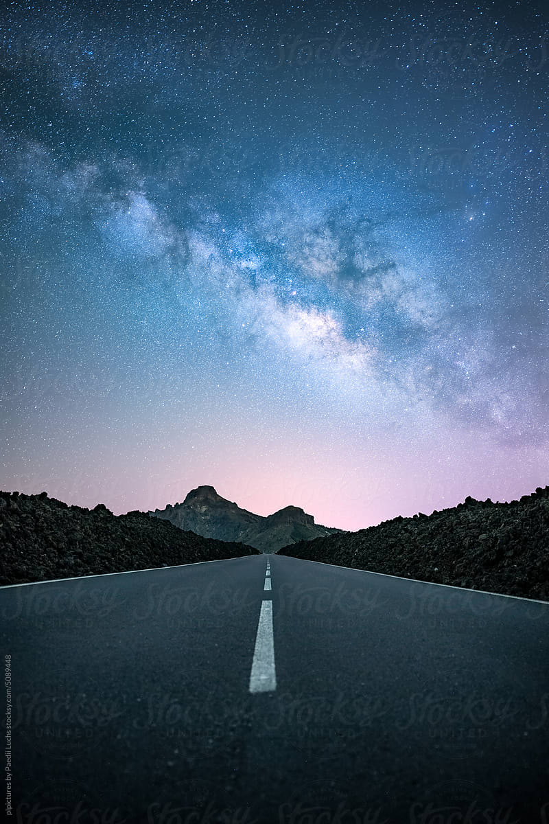 Milky way galaxy over straight road