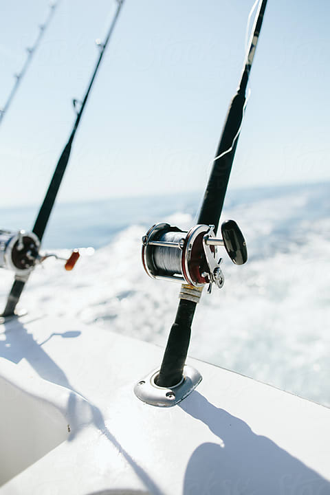 Fishing Rods And Spools Trolling From Back Of Boat by Stocksy Contributor  Luke Mattson - Stocksy
