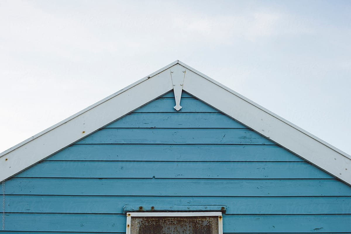 Apex of a wooden house against the sky with blue boards boards