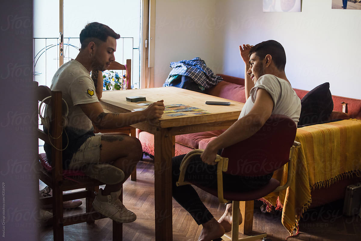 Gay latino couple at home with tarot cards