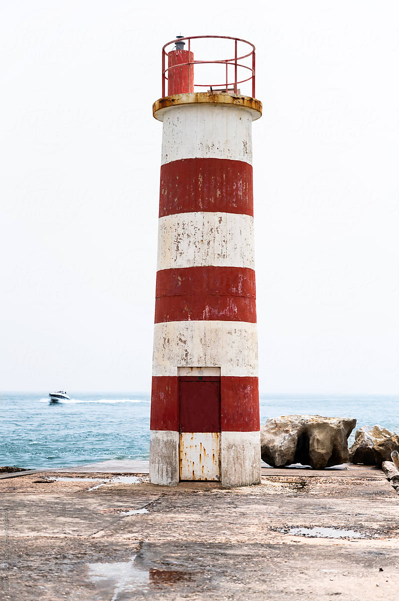 Lighthouse on seashore near sea