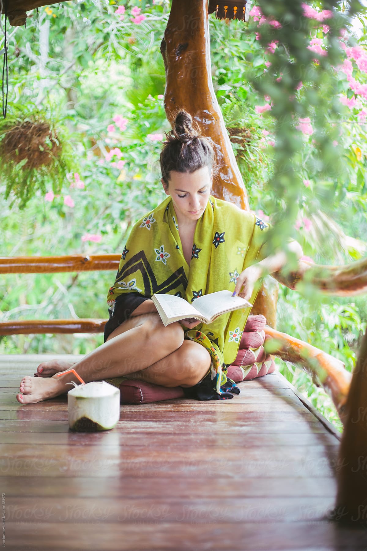 Woman Reading Book In Tropical Coffee Shop With Coconut By Stocksy Contributor Jovo Jovanovic