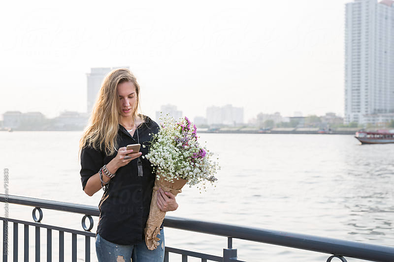 Young woman in the city holding a bouquet of flowers
