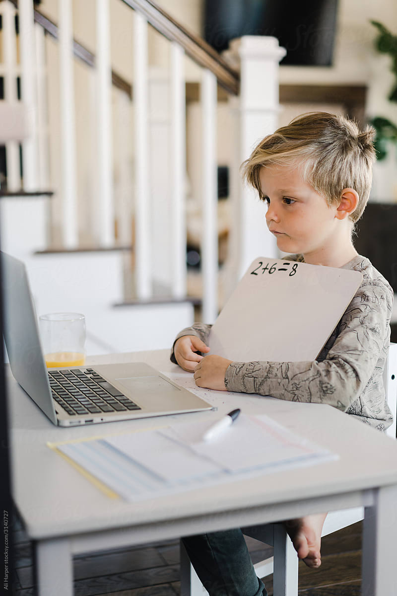 Little boy being homeschooled and doing work online